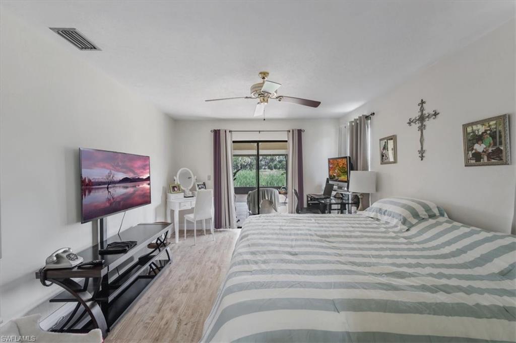 Bedroom with light wood-style floors, access to exterior, and ceiling fan