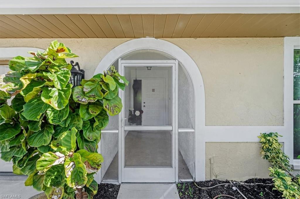 Entrance to property with stucco siding