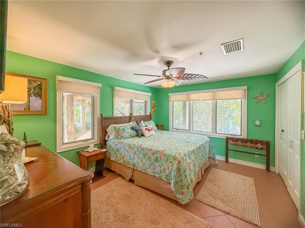 Tiled bedroom featuring ceiling fan, a closet, visible vents, and baseboards