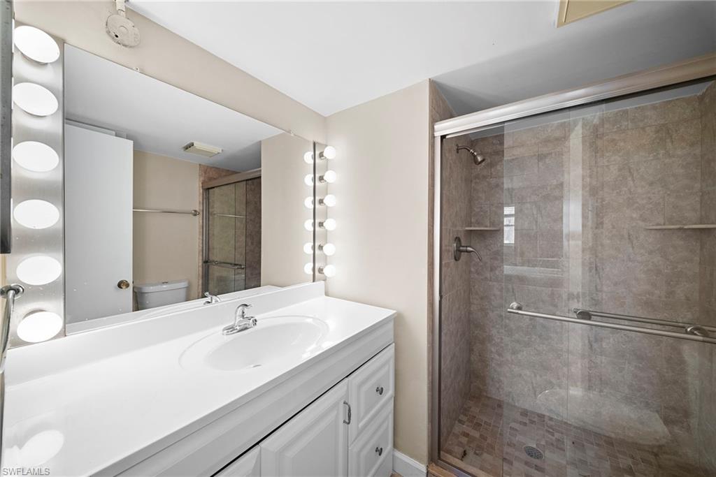 Full bathroom with vanity and a shower stall
