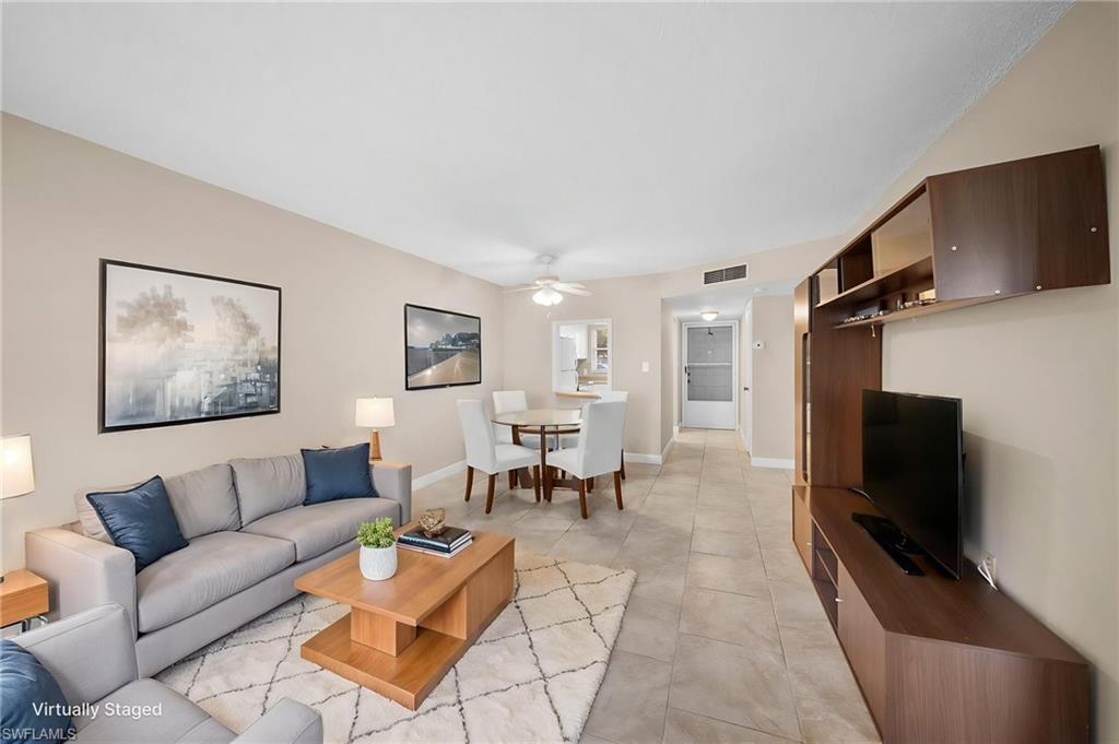 Living area with a ceiling fan and light tile patterned floors