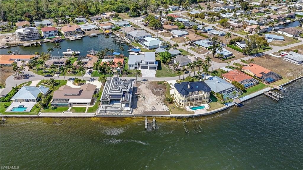 Aerial view of property and surrounding area with a large body of water and nearby suburban area