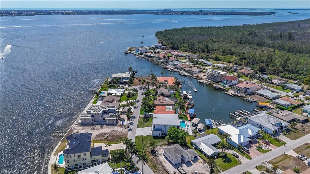 Aerial view of property and surrounding area featuring nearby suburban area and a large body of water