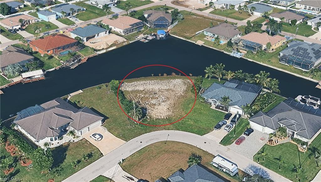 Aerial view of residential area featuring a nearby body of water