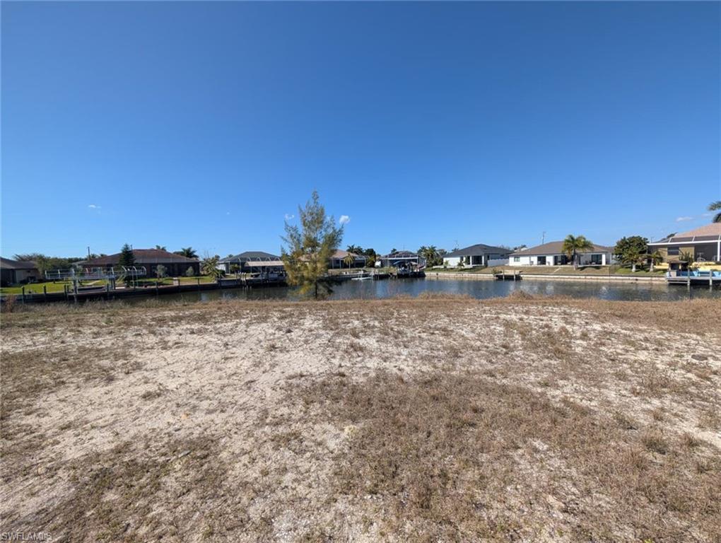 View of yard with a residential view and a water view