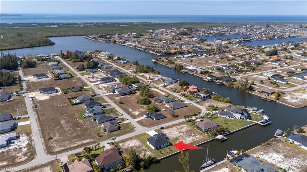 Aerial view of property and surrounding area with nearby suburban area and a nearby body of water