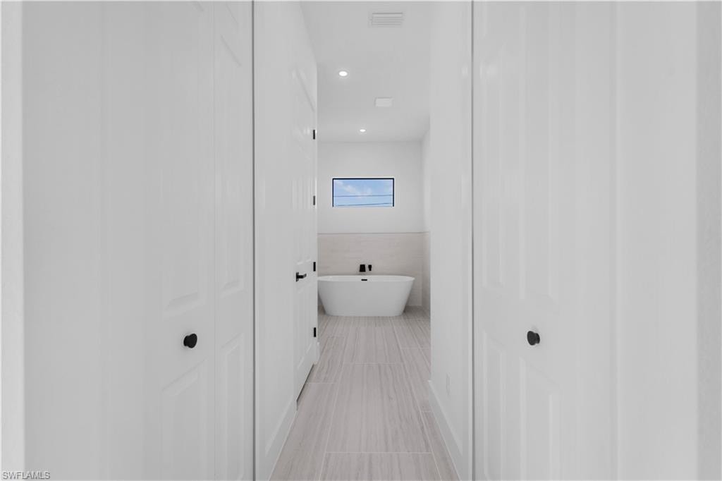 Master Bathroom with a freestanding bath, a closet, and recessed lighting