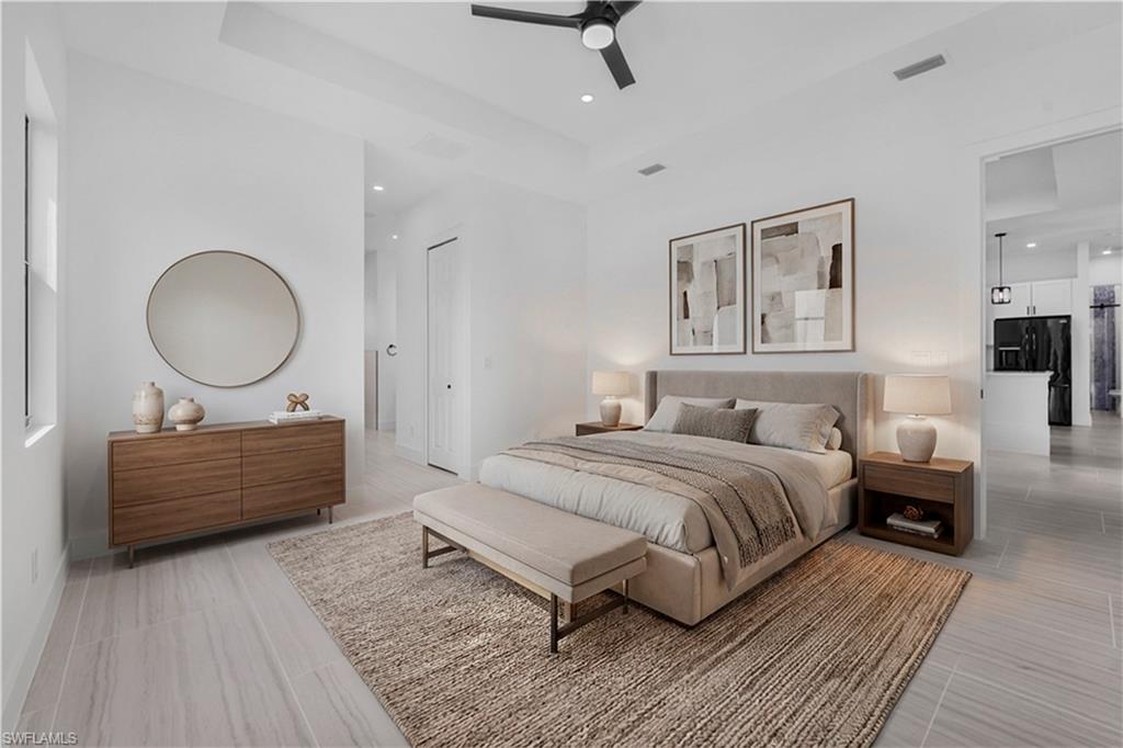 Bedroom featuring black fridge, ceiling fan, recessed lighting, and a raised ceiling
