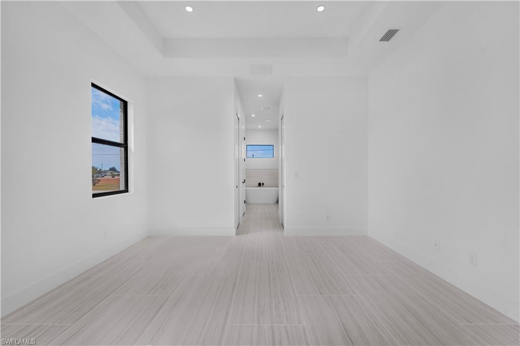Master bedroom featuring recessed lighting and a tray ceiling