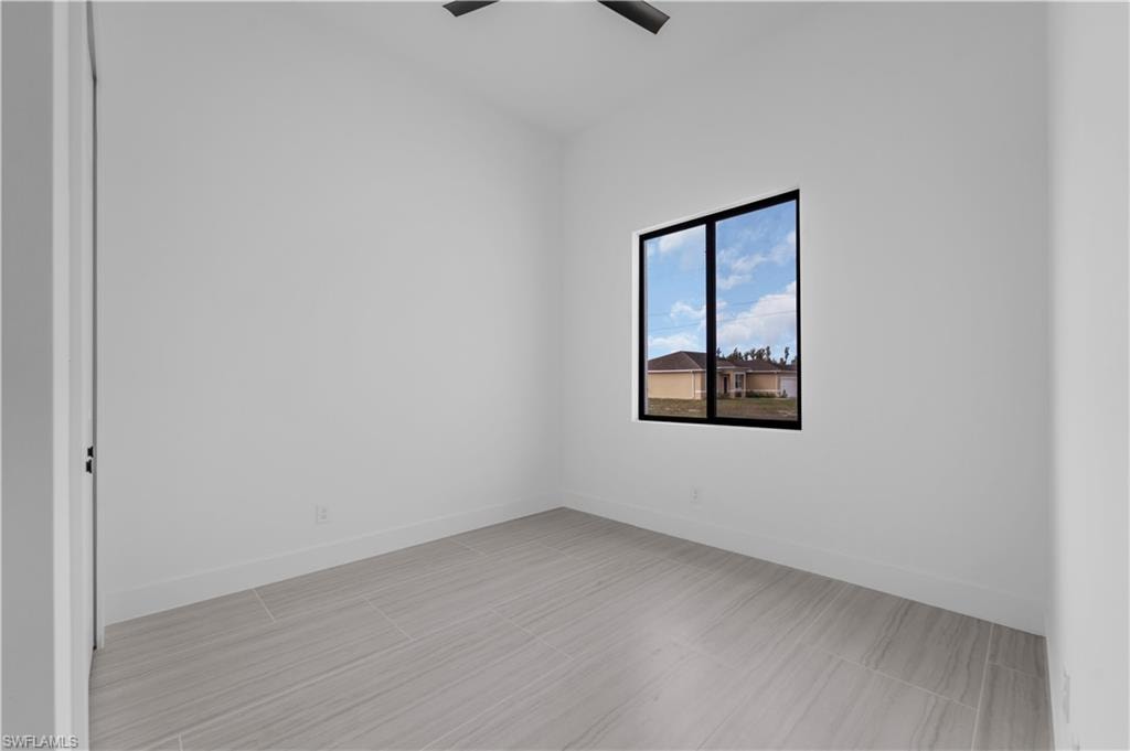 Spare room with baseboards and ceiling fan