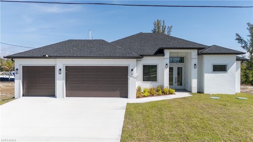View of front facade featuring a garage, a front lawn, french doors, concrete driveway, and a shingled roof