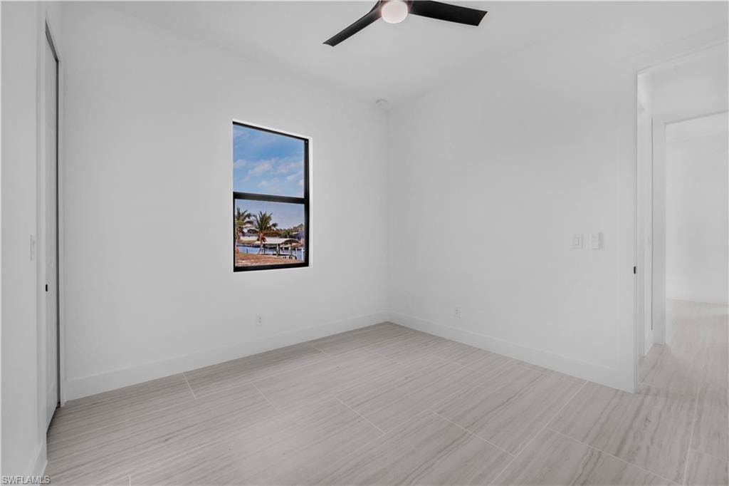 Empty room with ceiling fan and baseboards