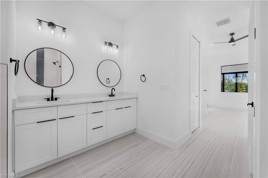 Full Maste bathroom featuring double vanity and a ceiling fan