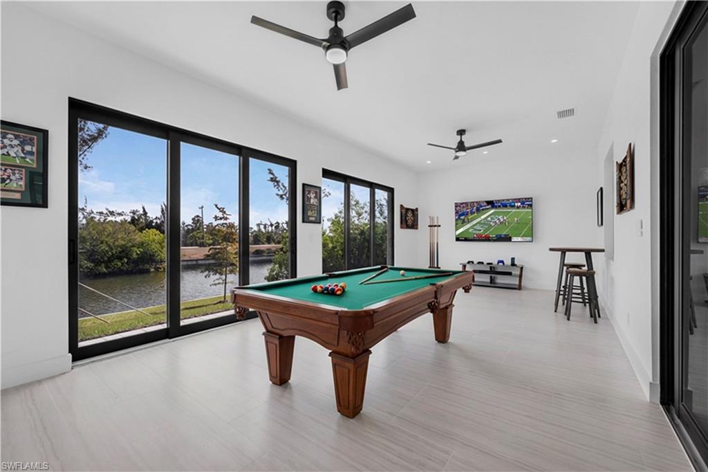 Recreation room with billiards table and a ceiling fan