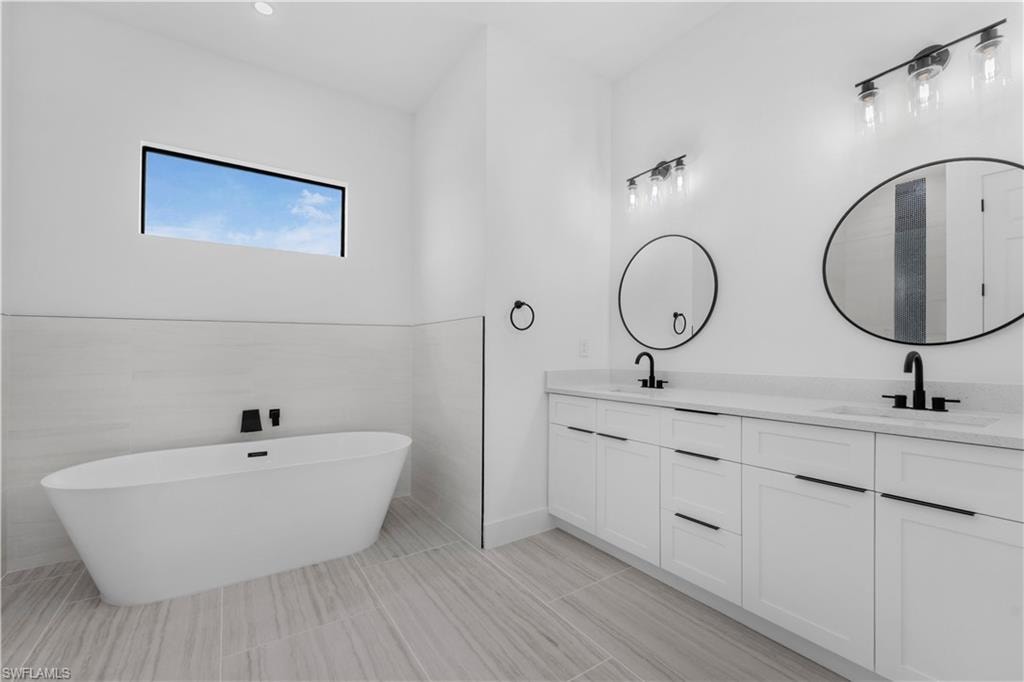 Master Bathroom with double vanity and a freestanding bath