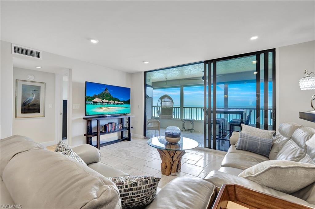 Living area with floor to ceiling windows, tile patterned floors, and recessed lighting