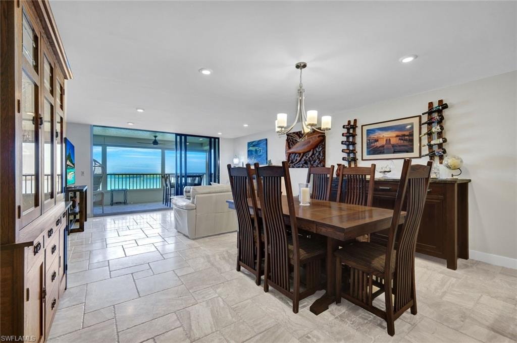 Dining room with suspended lighting, floor to ceiling windows, and a ceiling fan