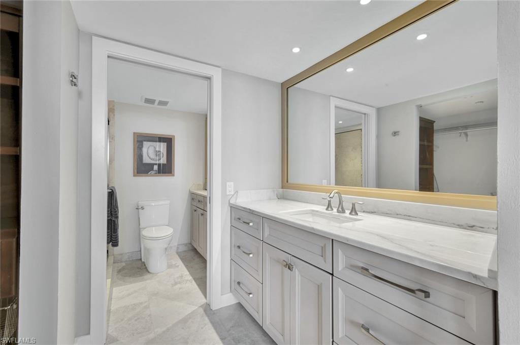Full bathroom with vanity and recessed lighting