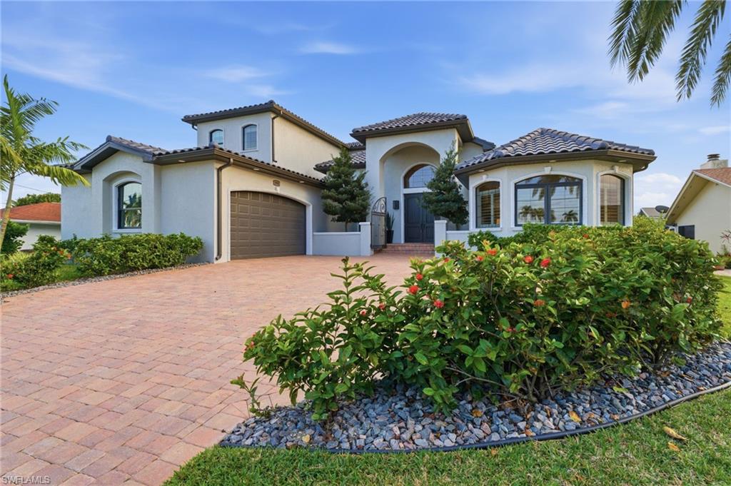 Mediterranean / spanish house with stucco siding, decorative driveway, a garage, and a tiled roof