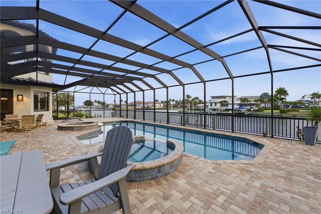 Relaxing pool / spa with a sunroom, a lanai, a patio, a water view, and a residential view