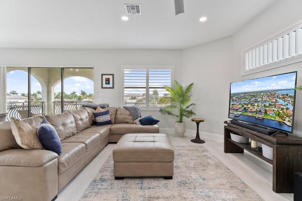 Living room featuring a ceiling fan, light wood-style flooring, and recessed lighting