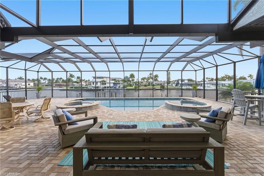 Integrated pool / hot tub with a sunroom, a patio, and a lanai