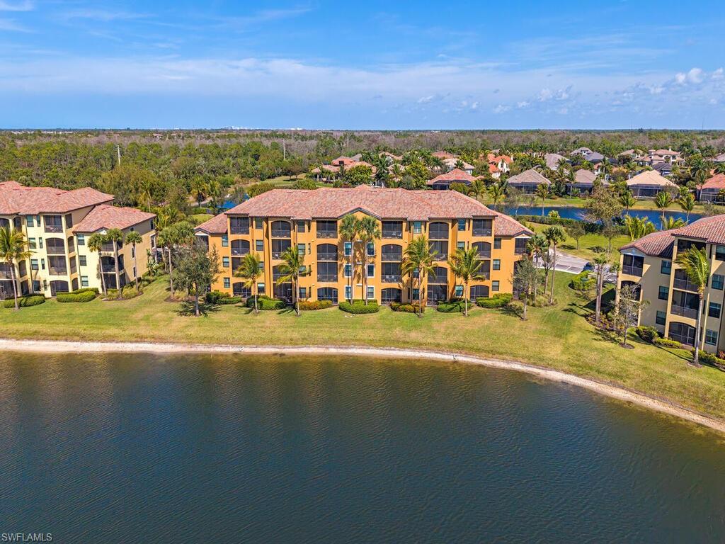 Drone / aerial view of a nearby body of water and apartment complex / building