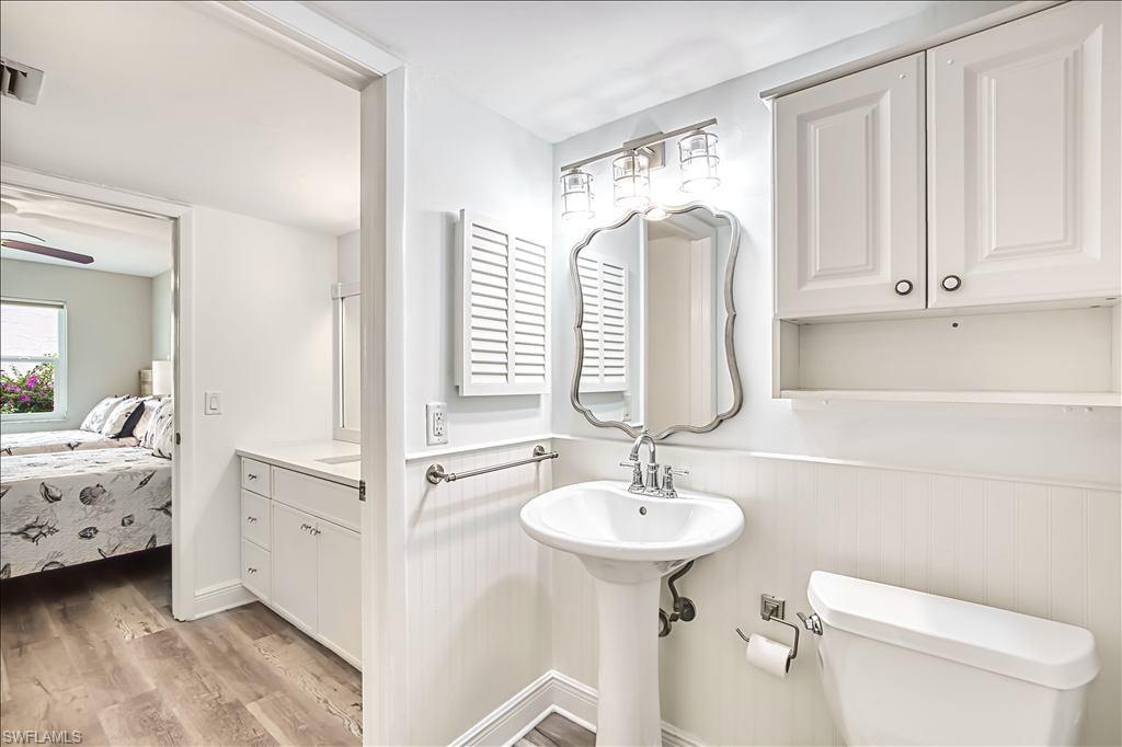 Ensuite bathroom featuring light wood finished floors and wainscoting