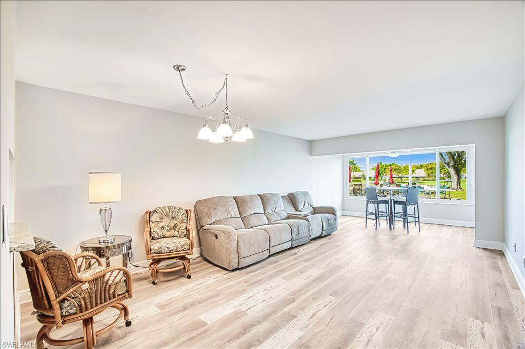 Living area with light wood-style floors and hanging lights