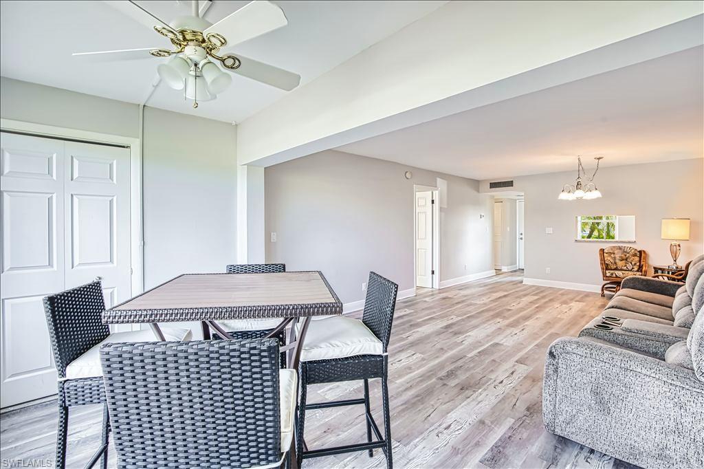 Dining space with light wood-style flooring, ceiling fan, and a chandelier