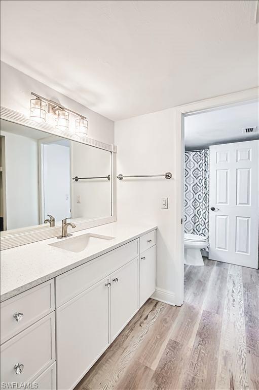 Full bathroom featuring vanity and light wood-style flooring
