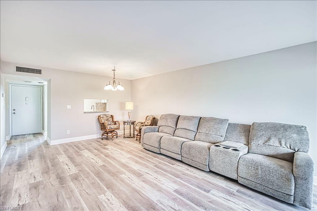 Living room with a chandelier and light wood-style flooring