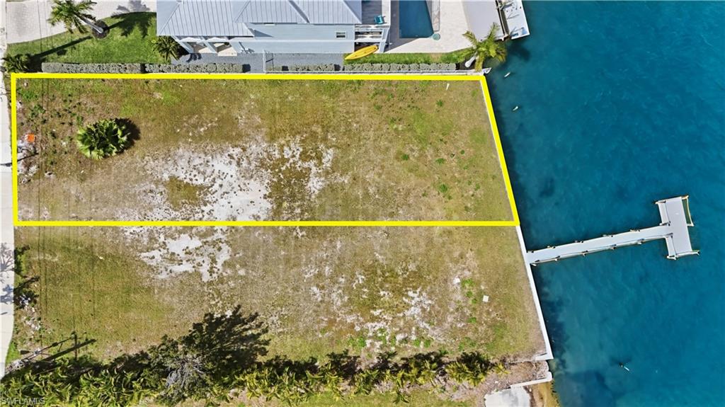 Aerial view of property's location with a nearby body of water and property parcel outlined - Virtually Edited Image