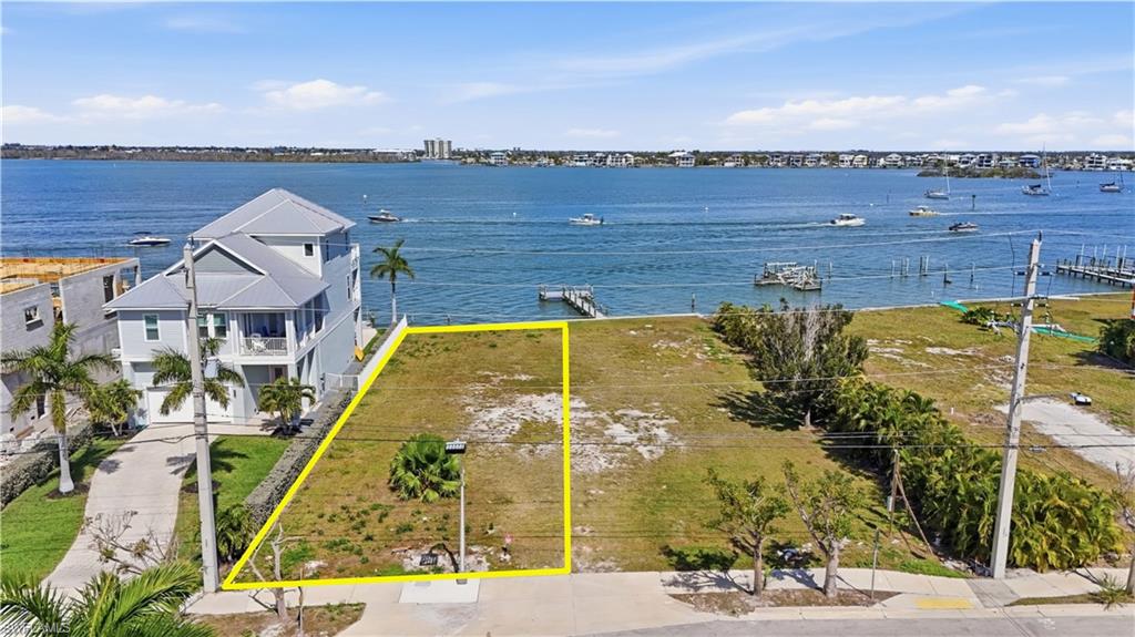 Aerial view of property's location with property parcel outlined and a nearby body of water - Virtually Edited Image