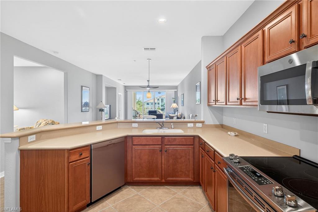 Kitchen with stainless steel appliances, wood finish cabinets, open floor plan, and recessed lighting