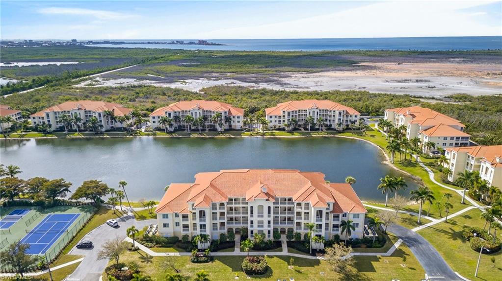 Drone / aerial view of a nearby body of water and apartment complex
