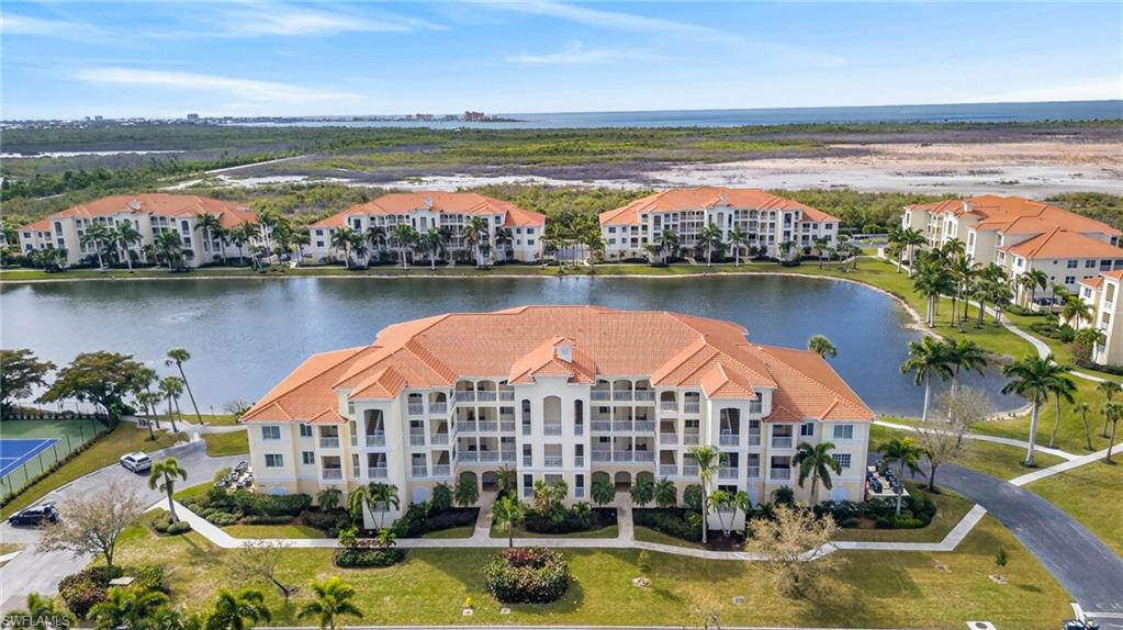 Drone / aerial view of apartment complex / building and a nearby body of water