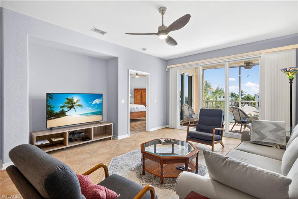 Living area with light tile patterned flooring and ceiling fan