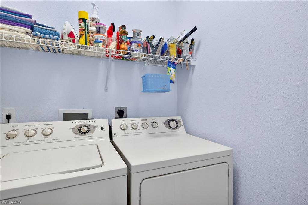 Laundry room with a textured wall and washing machine and clothes dryer