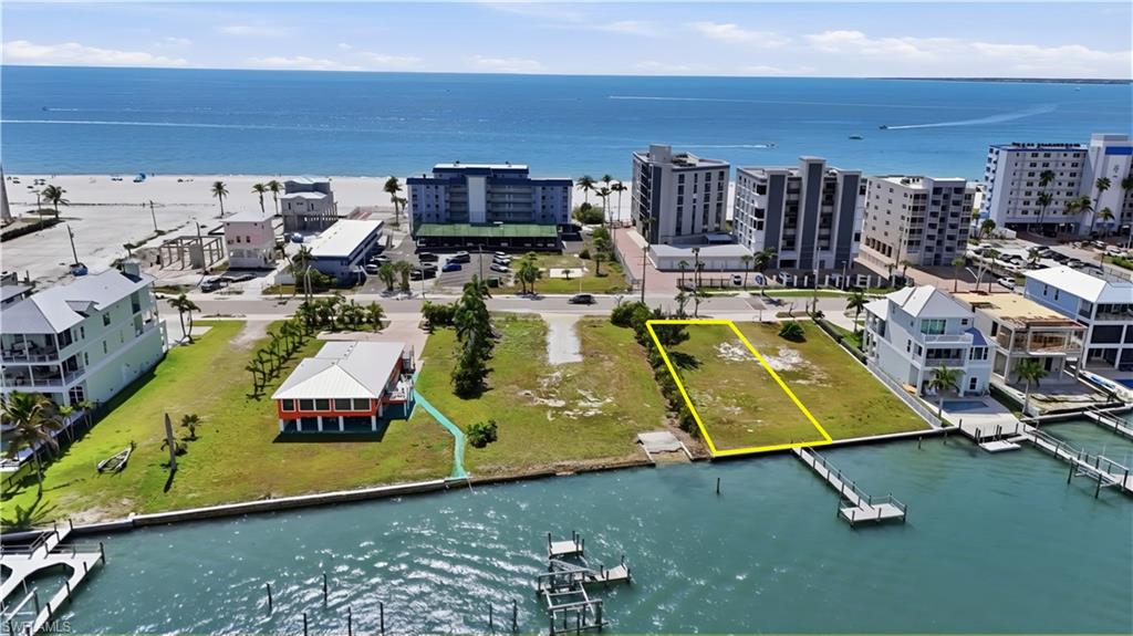 Aerial view of property's location featuring a large body of water and property parcel outlined - Virtually Edited Image