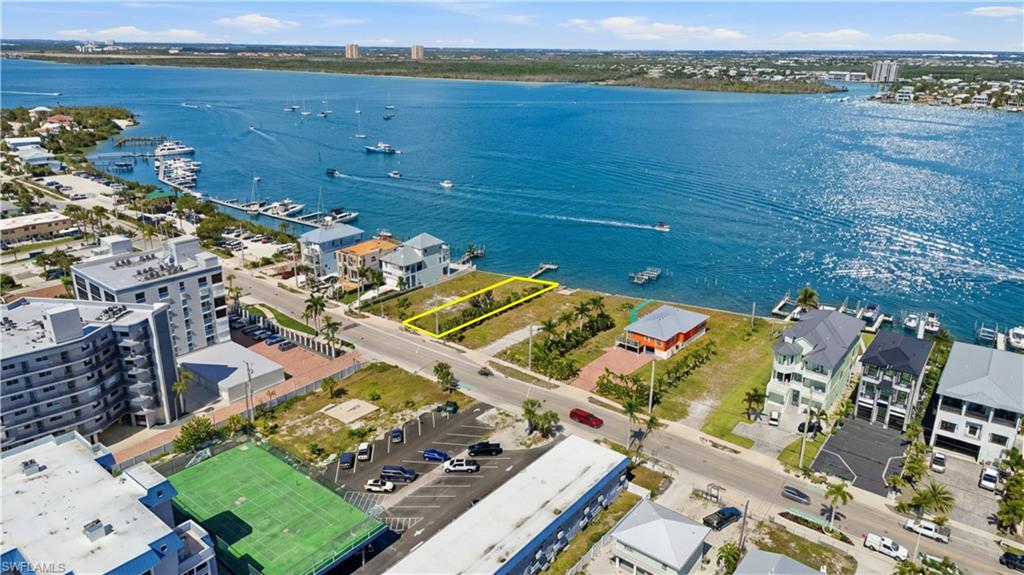 Aerial overview of property's location with a nearby body of water and property parcel outlined - Virtually Edited Image
