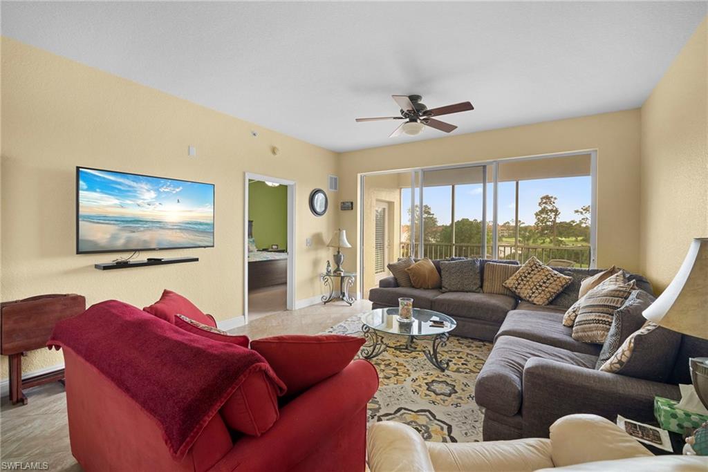 Living area with a ceiling fan and baseboards