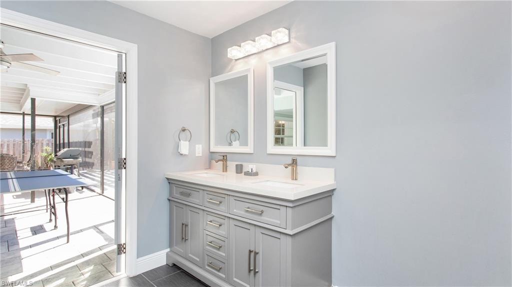 Full bathroom featuring double vanity and baseboards