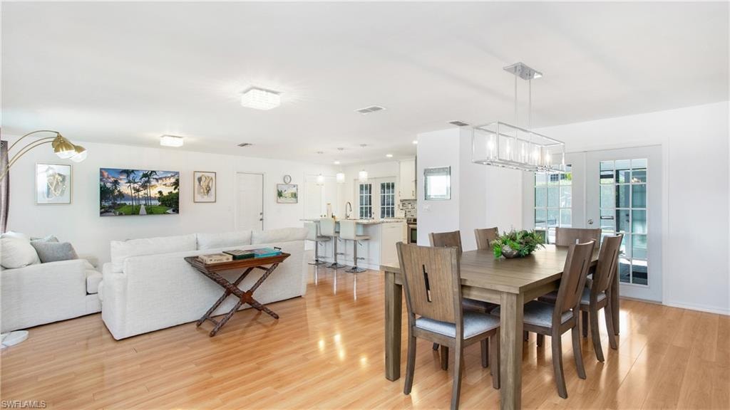 Dining area with light wood-style floors and a chandelier