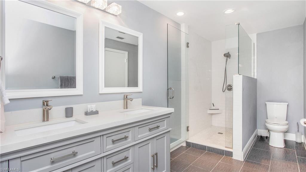 Bathroom with double vanity, a stall shower, and recessed lighting