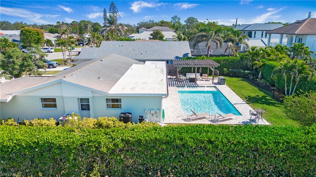 Outdoor pool with a pergola, a patio area, a residential view, and a lawn
