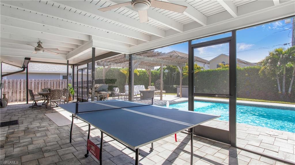 Fenced backyard featuring a ceiling fan, outdoor dining area, a patio area, and a sunroom