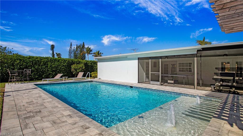 View of pool with patio surround and a sunroom