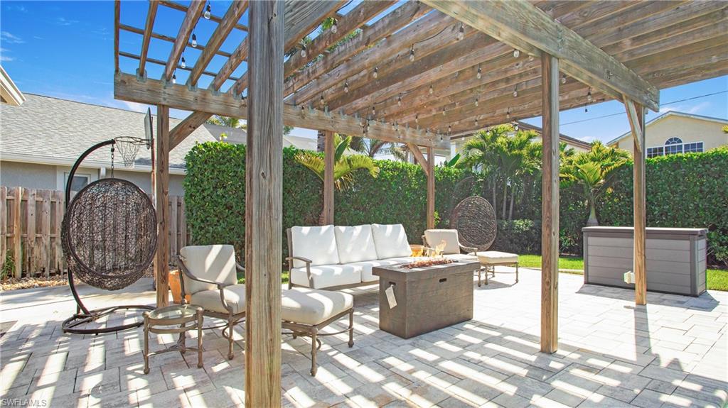 Fenced backyard featuring an outdoor living space with a fire pit, a patio area, and a pergola