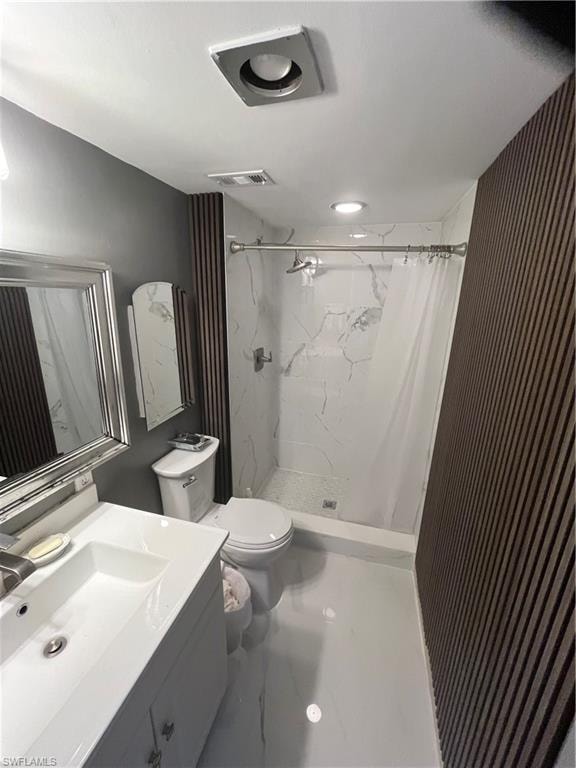 Bathroom with vanity and a marble finish shower